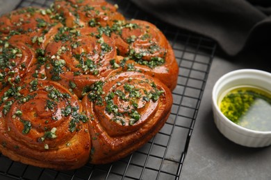 Photo of Traditional Ukrainian garlic bread with herbs (Pampushky) on grey table, closeup. Space for text