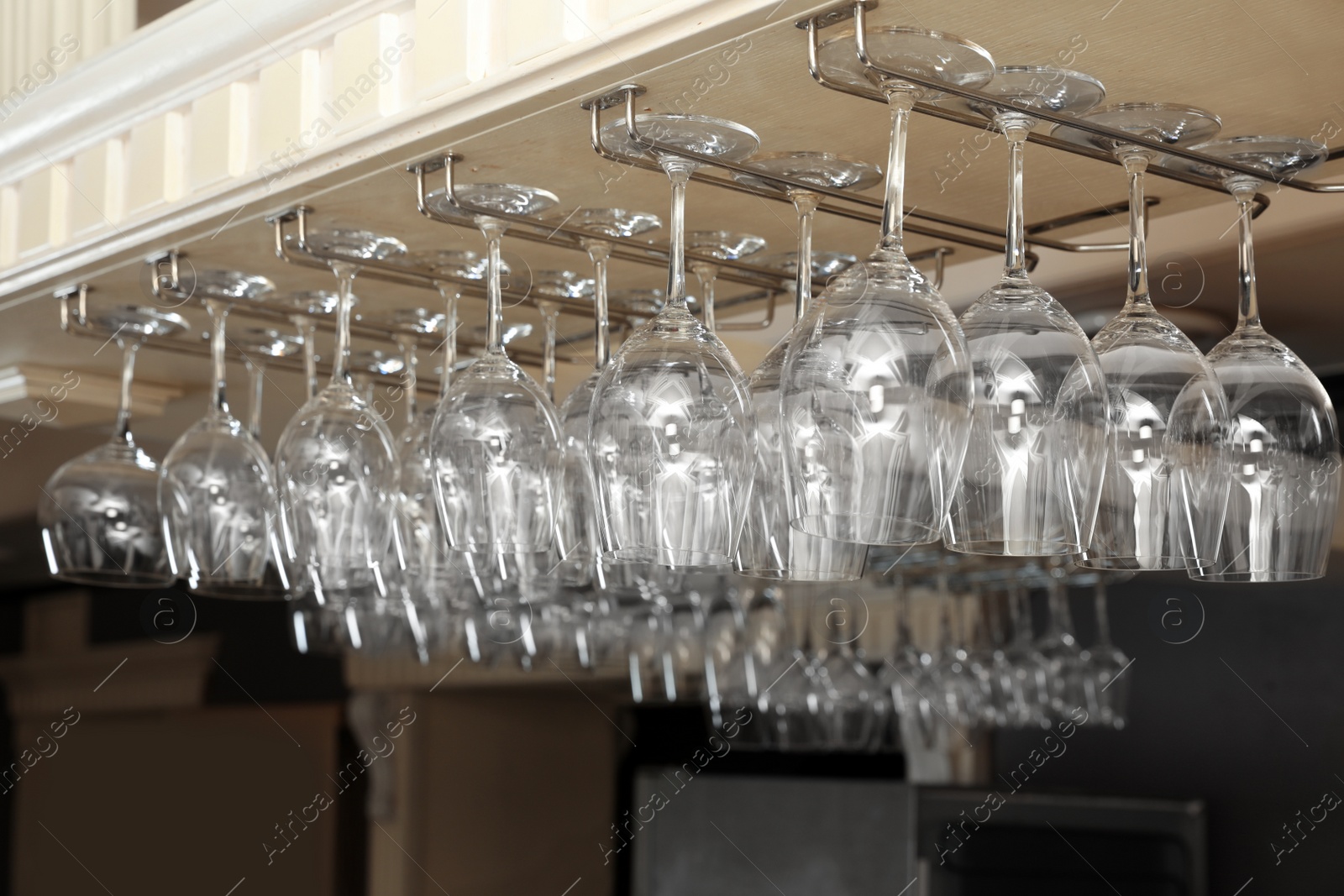 Photo of Set of empty clean glasses on bar racks