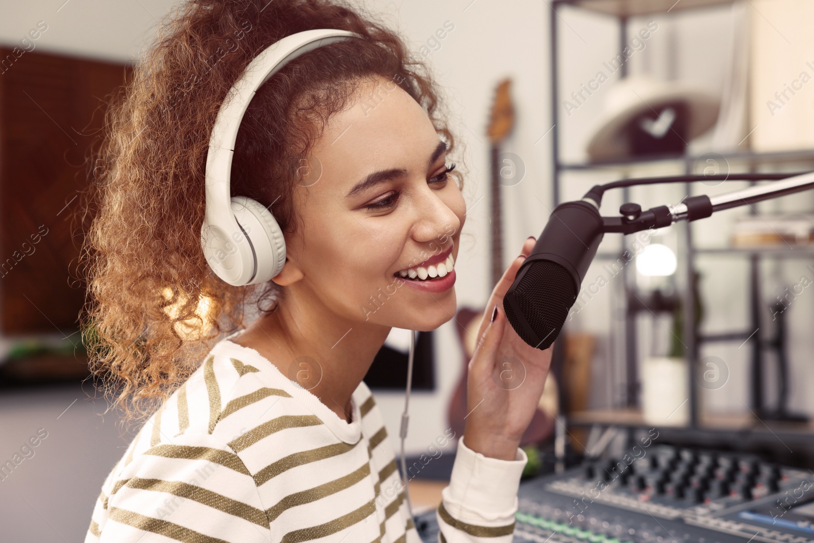 Photo of African American woman working as radio host in modern studio