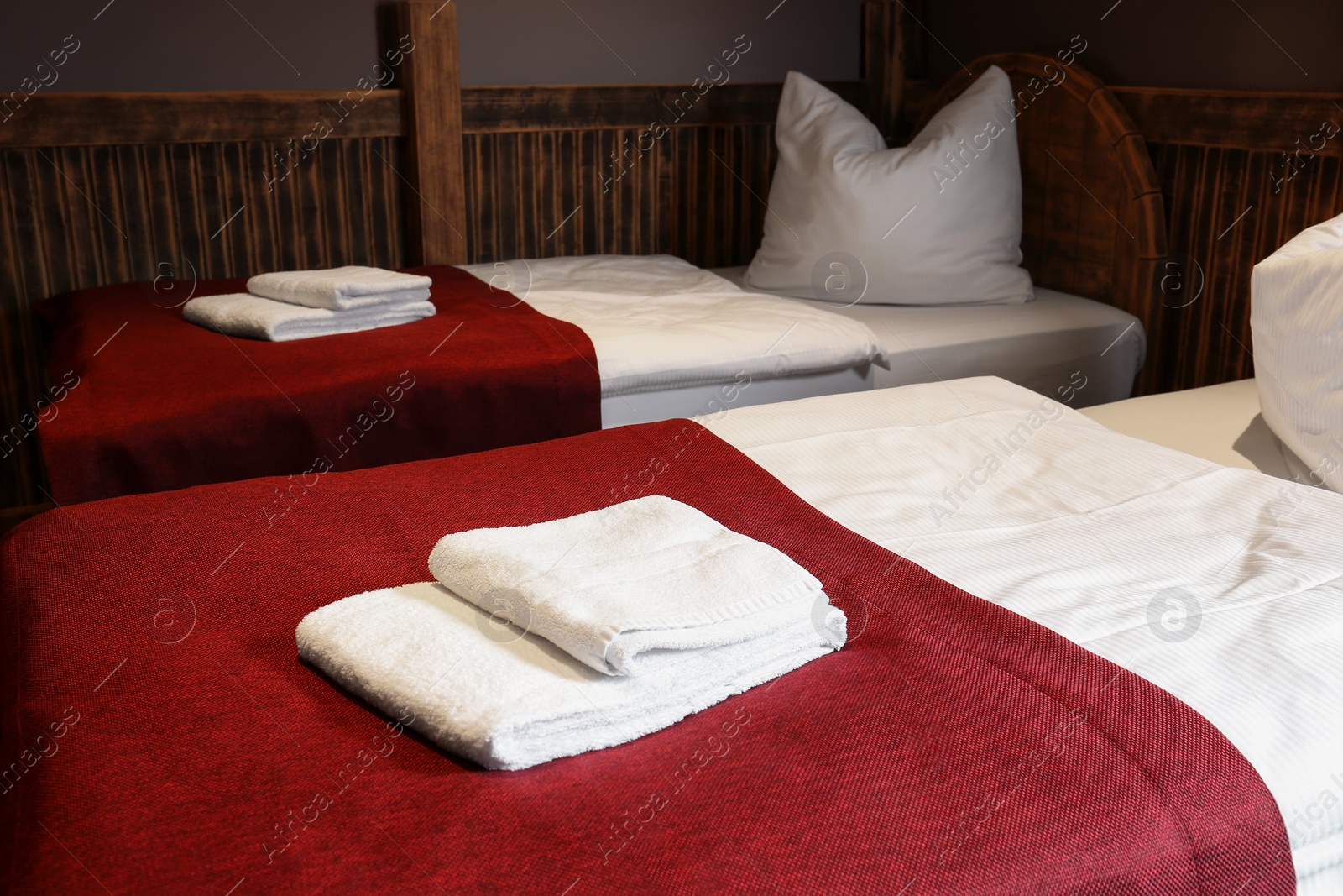 Photo of Clean folded towels on bed in hotel room