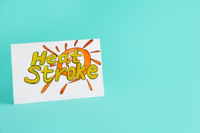 Photo of Card with words Heat Stroke on turquoise background, space for text