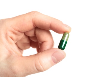 Photo of Woman holding spirulina pill on white background, closeup