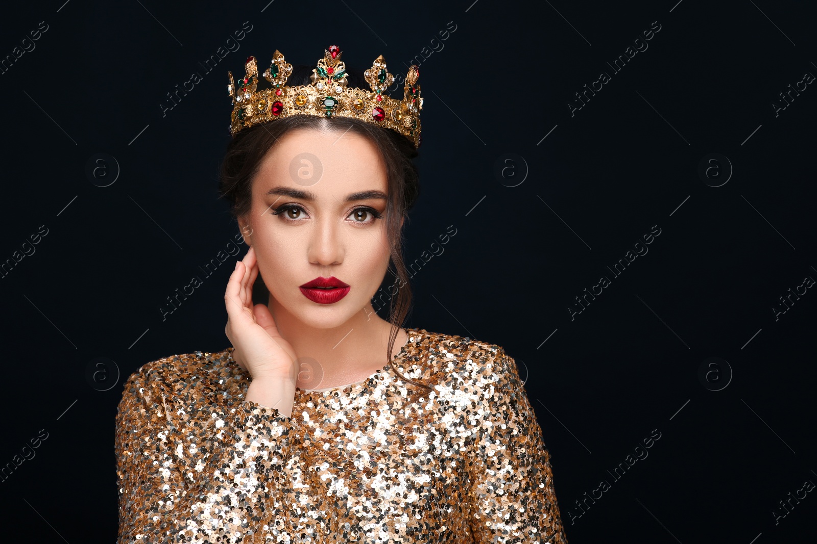 Photo of Beautiful young woman wearing luxurious crown on black background, space for text