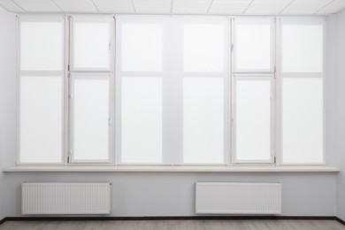 Photo of Window with closed white roller blinds indoors