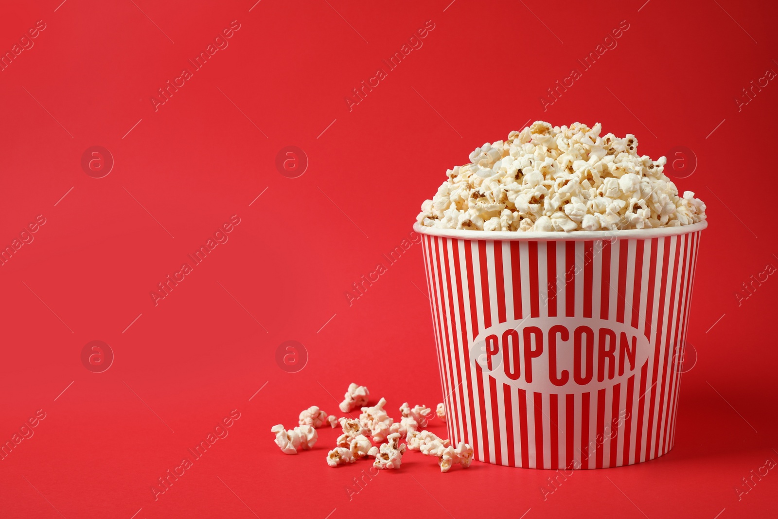 Photo of Delicious popcorn on red background. Space for text