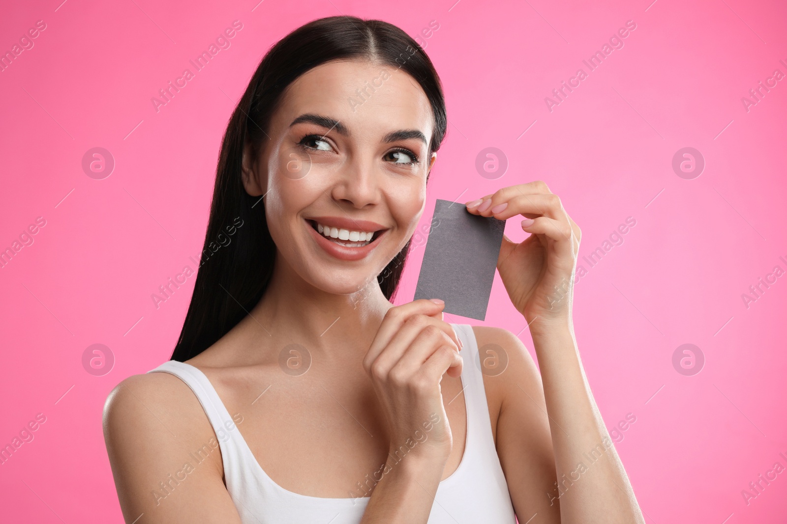 Photo of Beautiful woman with mattifying wipe on pink background