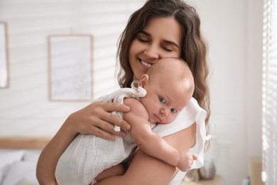 Happy young mother with her cute baby at home