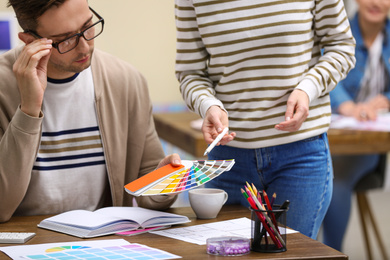 Photo of Professional interior designer with colleague working in office, closeup