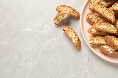 Photo of Traditional Italian almond biscuits (Cantucci) on light marble table, flat lay. Space for text