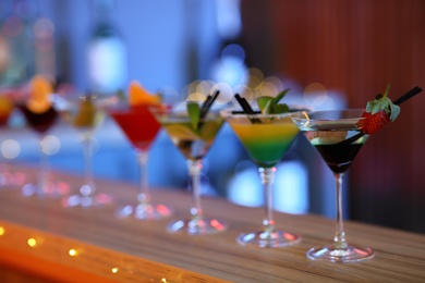 Photo of Different martini cocktails on table in bar, space for text