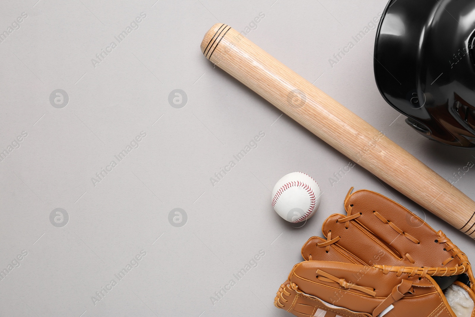 Photo of Baseball glove, bat, ball and batting helmet on light grey background, flat lay. Space for text