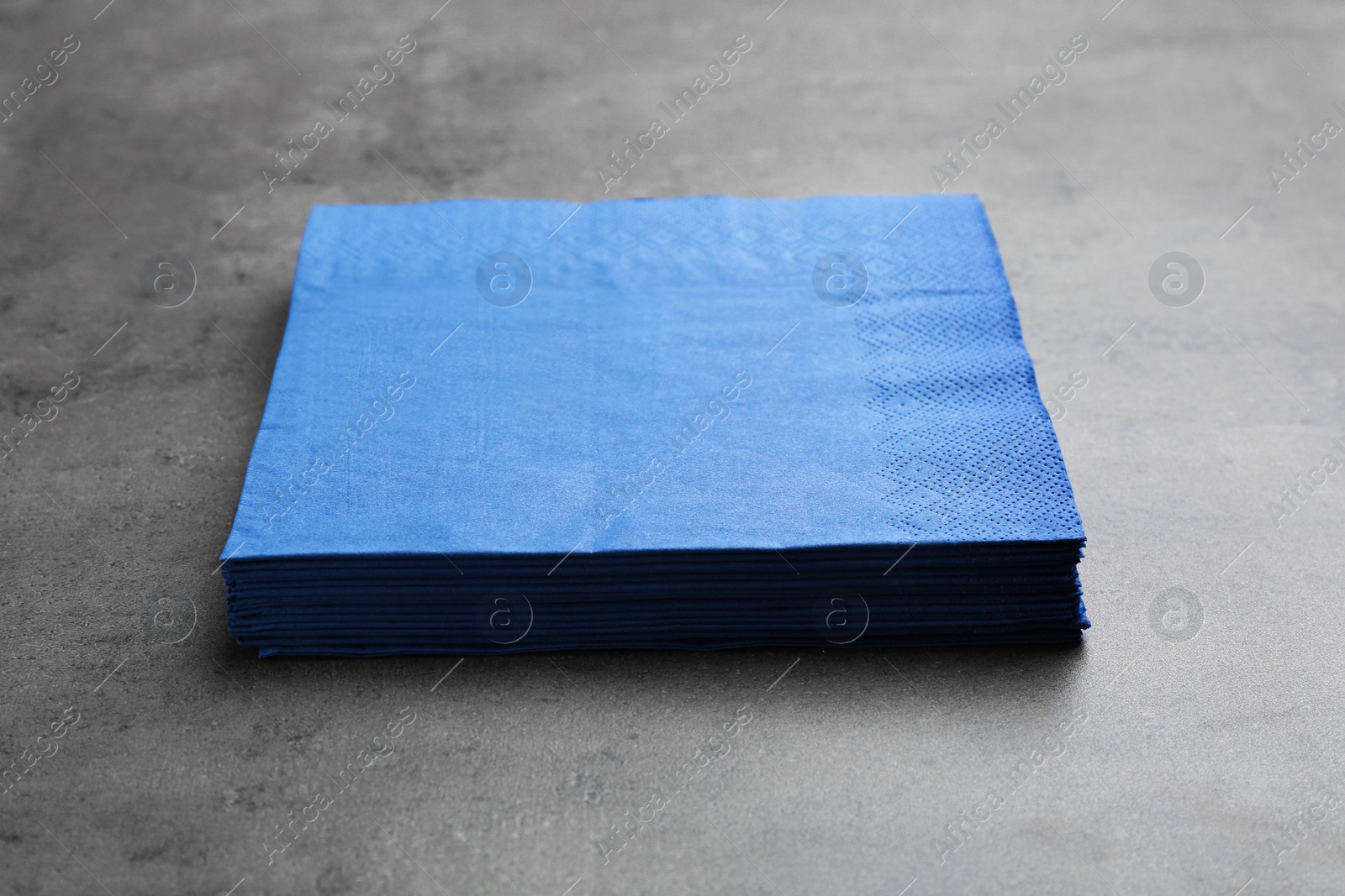 Photo of Stack of paper napkins on grey background