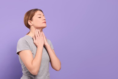 Photo of Woman suffering from sore throat on violet background. Space for text