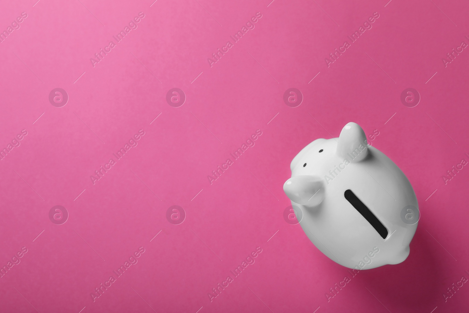 Photo of Ceramic piggy bank on pink background, top view with space for text. Financial savings