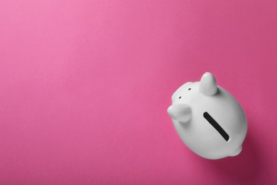 Ceramic piggy bank on pink background, top view with space for text. Financial savings