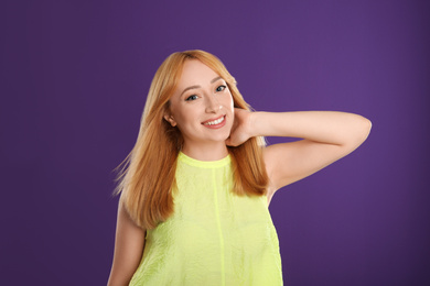 Photo of Beautiful young woman with blonde hair on purple background