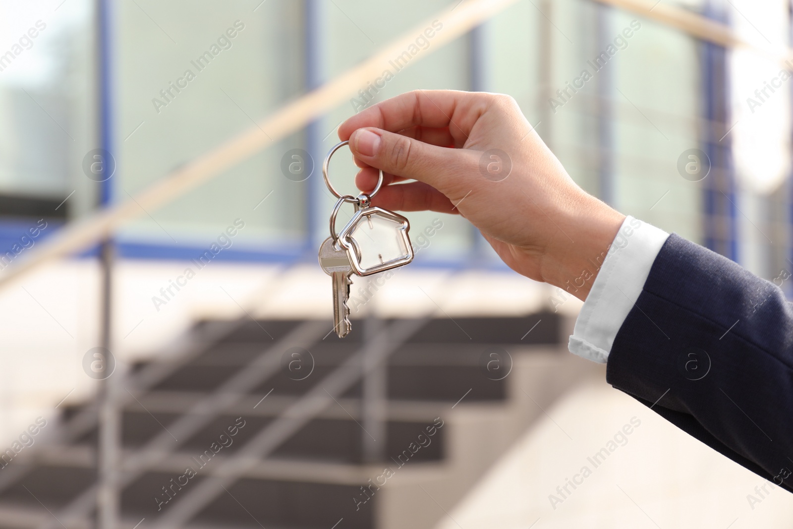 Photo of Real estate agent holding key outdoors, closeup