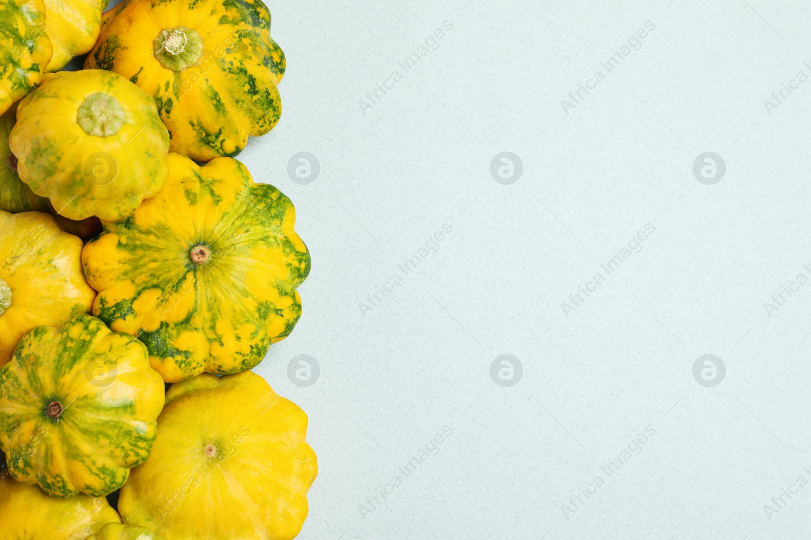 Photo of Fresh ripe pattypan squashes on light background, flat lay. Space for text