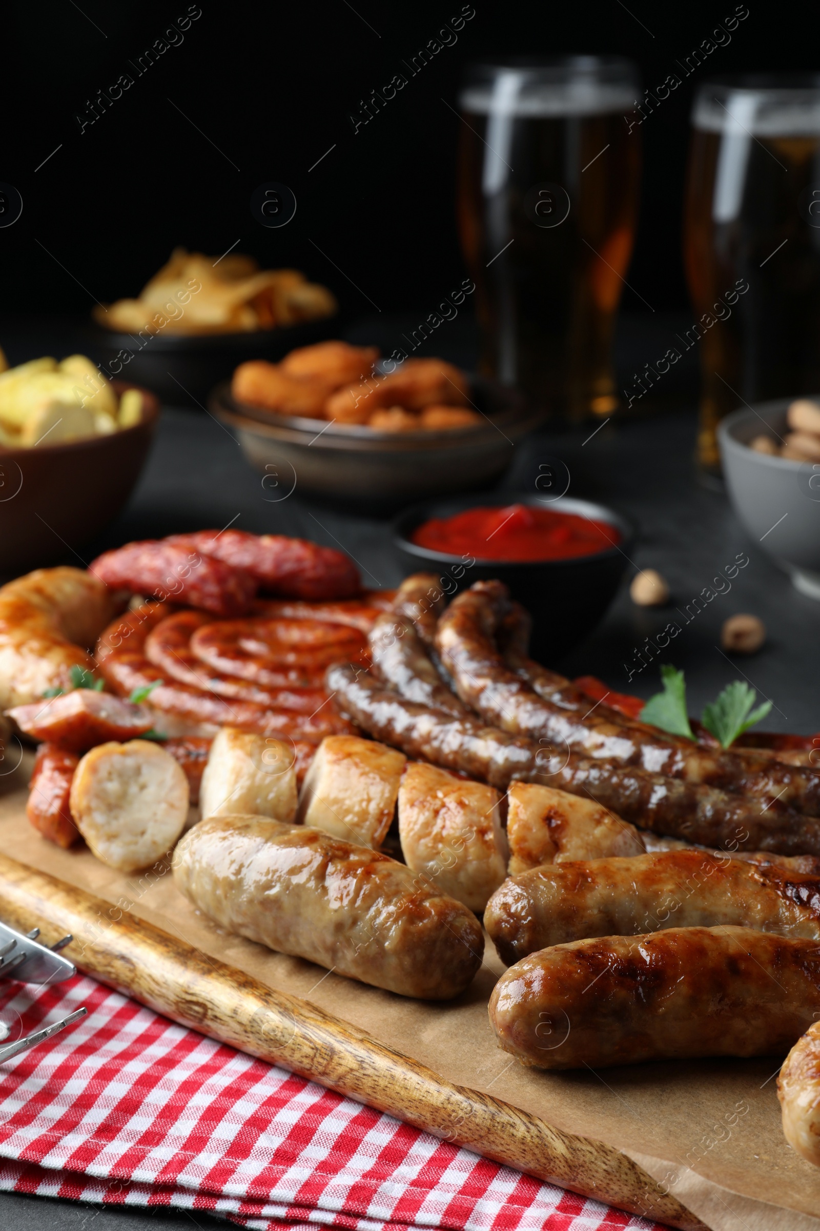 Photo of Set of different tasty snacks on wooden board, closeup view