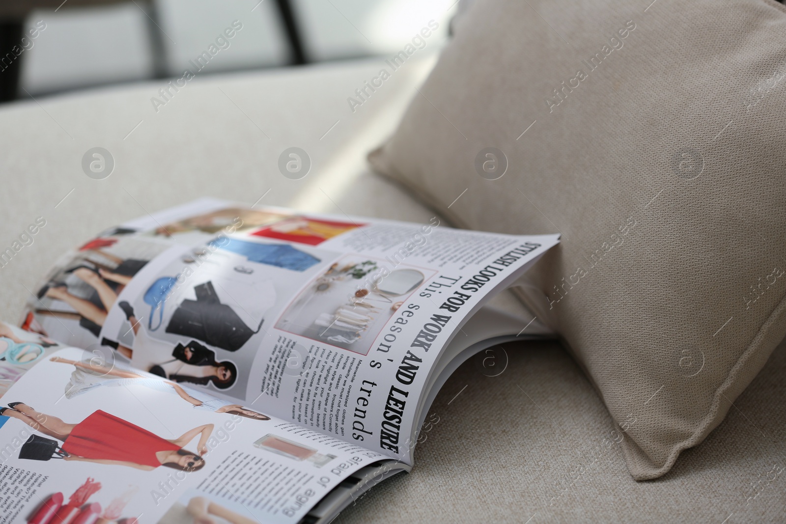 Photo of Open fashion magazine on sofa in living room