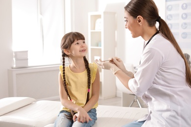 Photo of Doctor examining adorable child in hospital office