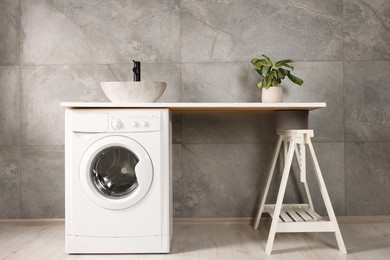 Photo of Stylish laundry room with modern washing machine. Interior design