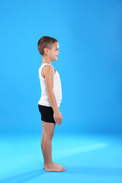 Cute little boy in underwear on light blue background