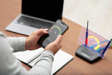 Image of 5G speed test. Man using mobile phone at table, closeup