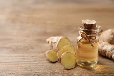 Ginger essential oil in bottle on wooden table. Space for text