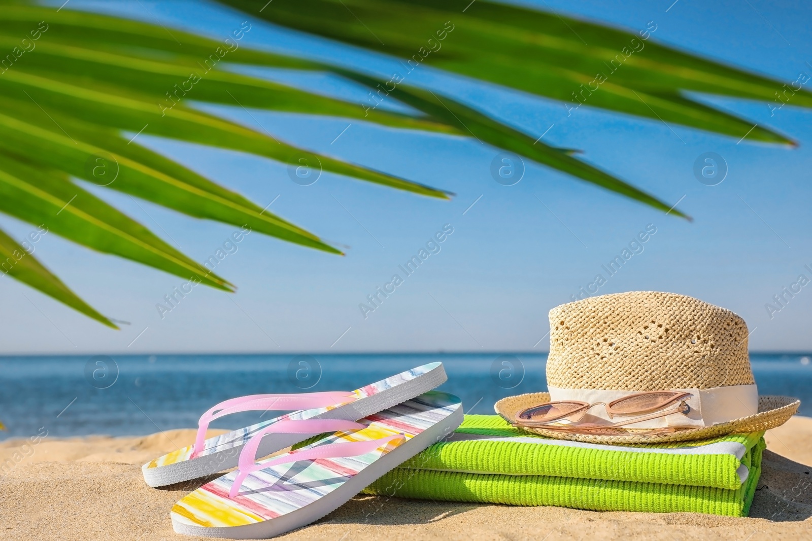 Photo of Set with stylish beach accessories on sand near sea