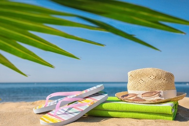 Set with stylish beach accessories on sand near sea