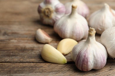 Photo of Fresh organic garlic on wooden table, closeup