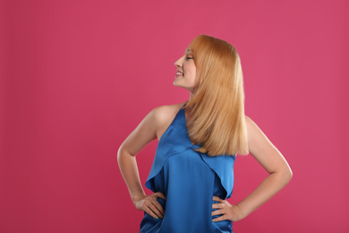 Photo of Beautiful young woman with blonde hair on pink background