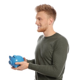 Young man with piggy bank on white background