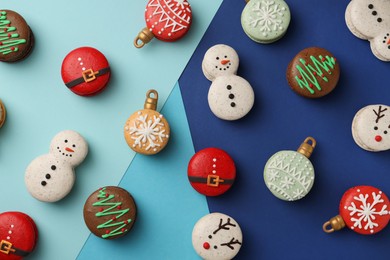 Photo of Beautifully decorated Christmas macarons on color background, flat lay