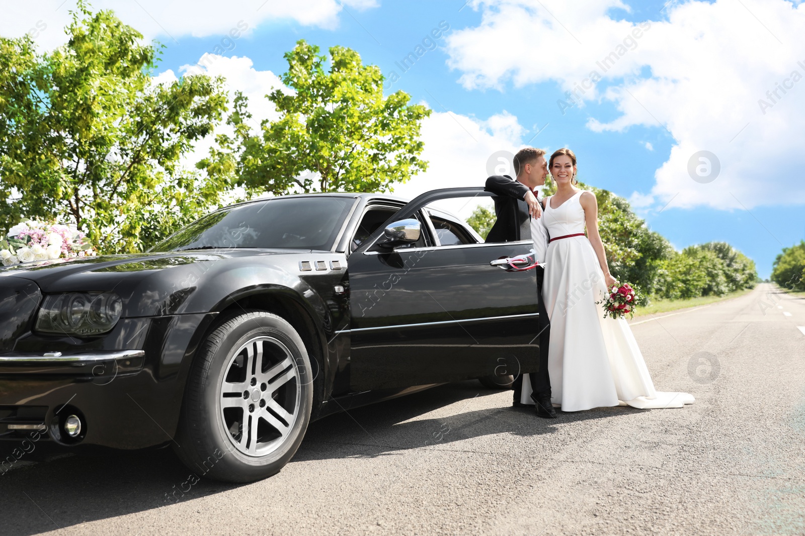 Photo of Happy bride and groom near car outdoors