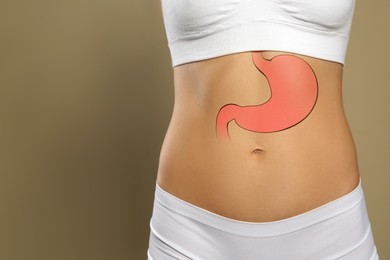 Image of Woman with image of healthy stomach on beige background, closeup. Space for text
