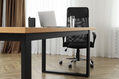 Photo of Director's office with large wooden table and comfortable armchair. Interior design