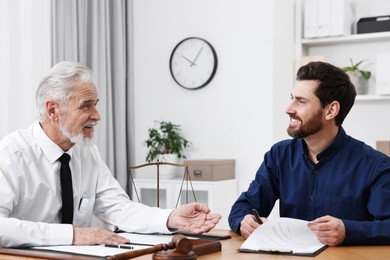 Photo of Man signing document at table in lawyer's office