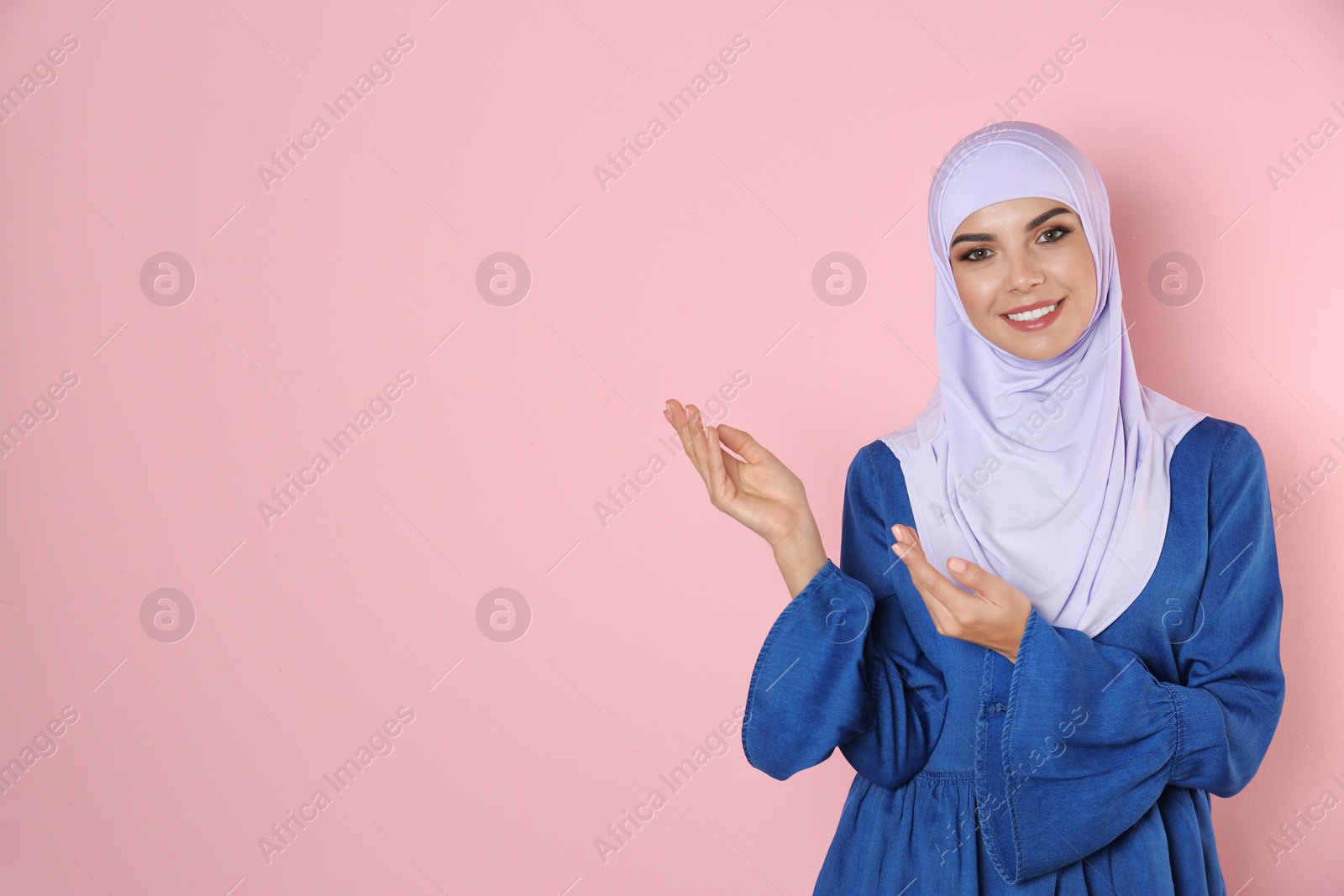 Photo of Portrait of young Muslim woman in hijab against color background. Space for text