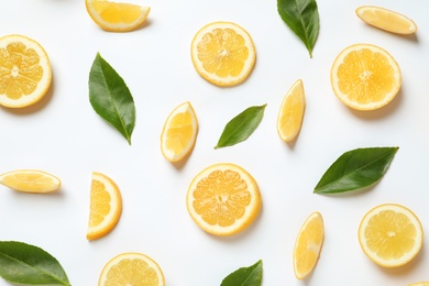 Fresh lemons and leaves on white background, top view. Citrus fruits