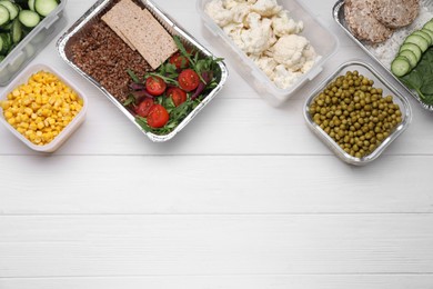 Different containers with fresh products on white wooden table, flat lay. Space for text