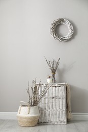 Photo of Fresh pussy willow branches and wicker baskets indoors
