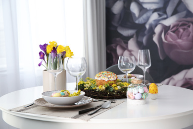 Festive Easter table setting with beautiful flowers and eggs indoors