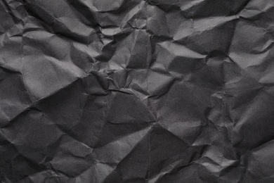 Photo of Sheet of black crumpled paper as background. Space for design