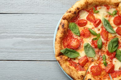 Photo of Delicious Margherita pizza on gray wooden table, top view. Space for text