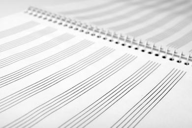 Notebook with empty staves for music notes as background, closeup