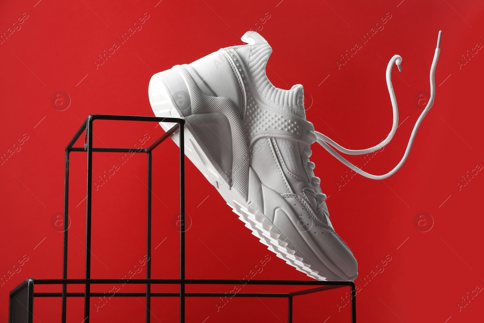 Photo of Stylish presentation of one sneaker on red background