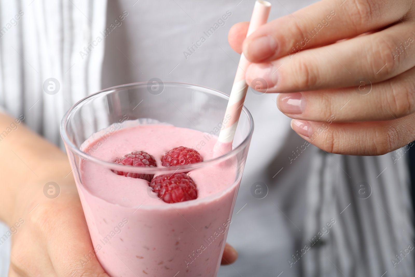 Image of Woman with glass of tasty raspberry smoothie, closeup