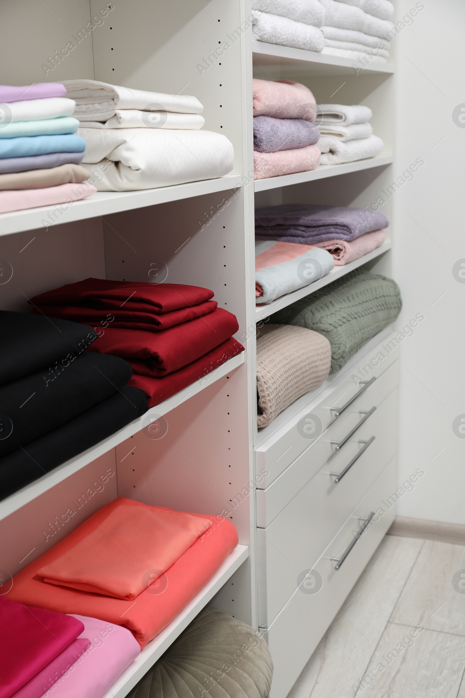 Photo of Different color linens on shelves in shop